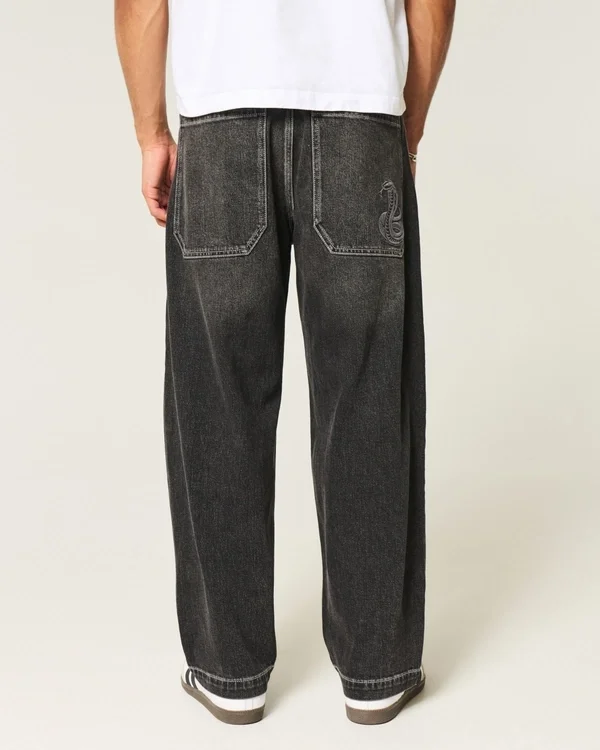 Gewaschene schwarze Baggy-Jeans mit Schlangenstickerei Gewaschene schwarze Baggy-Jeans mit Schlangenstickerei