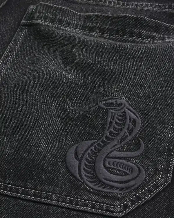 Gewaschene schwarze Baggy-Jeans mit Schlangenstickerei Gewaschene schwarze Baggy-Jeans mit Schlangenstickerei