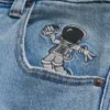 Hellblaue Super-Baggy-Jeans mit Astronauten-Grafik Hellblaue Super-Baggy-Jeans mit Astronauten-Grafik