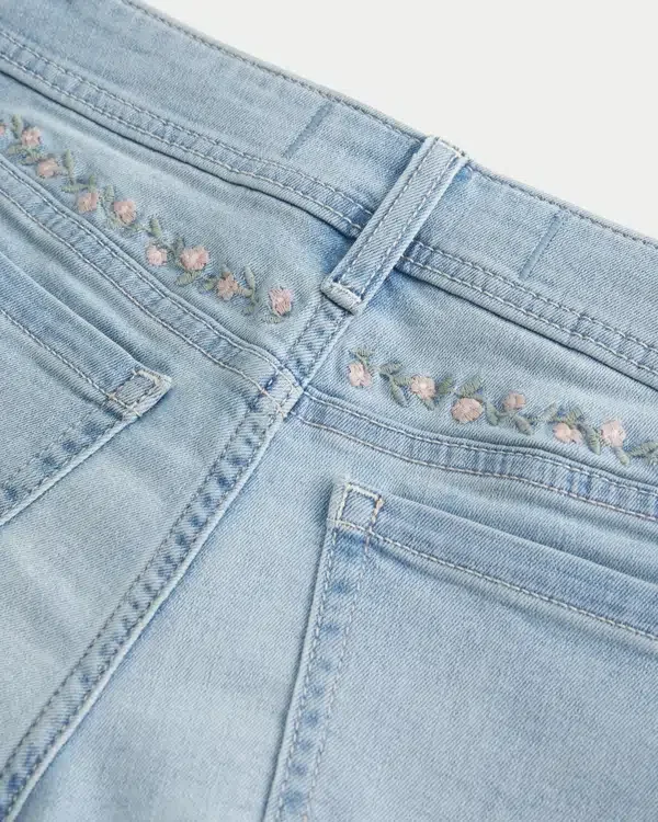 Kurvige, niedrig geschnittene, hell gewaschene Denim-Shorts mit Blumenstickerei Kurvige, niedrig geschnittene, hell gewaschene Denim-Shorts mit Blumenstickerei