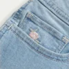 Kurvige, niedrig geschnittene, hell gewaschene Denim-Shorts mit Blumenstickerei Kurvige, niedrig geschnittene, hell gewaschene Denim-Shorts mit Blumenstickerei