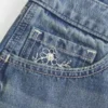 Ultra Low-Rise Mini-Shorts aus mittelblauem Denim mit Blumenstickerei